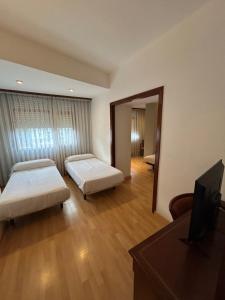 a hotel room with two beds and a mirror at Hotel Unzaga Plaza in Éibar +41 photos
