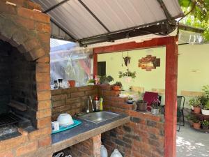 eine Küche mit einer Spüle in einer Ziegelwand in der Unterkunft Căsuța Verde in 2 Mai