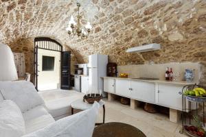 a living room with a white couch and a kitchen at Antonia's House - Old town in Rethymno