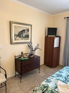 a bedroom with a bed and a dresser with a tv at Iremia in Kariá