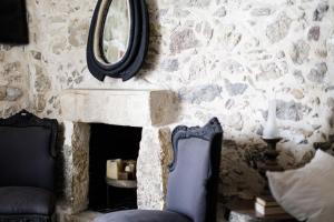 a stone wall with a mirror and a chair at Antonia's stonebuilt mansion with a private pool in Arménoi +13 photos