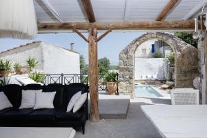 a living room with a black couch and an arch at Antonia's stonebuilt mansion with a private pool in Arménoi