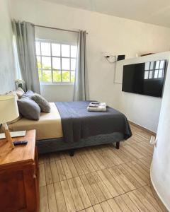 a bedroom with a bed and a flat screen tv at Coco apartamento centrico in Cozumel