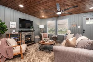 een woonkamer met een bank en een open haard bij Hot Tub - Fire Pit - River - State Park - King Bed in Wingina