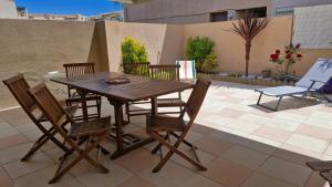 a wooden table and chairs on a patio at Résidence les Sables D'or in Cap d'Agde