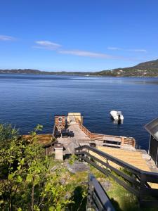 a dock on a large body of water with a boat at En Perle ved Masfjorden in Masfjorden