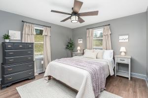 een slaapkamer met een bed en een plafondventilator bij Hot Tub - Fire Pit - River - State Park - King Bed in Wingina