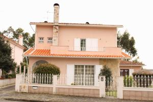 a pink house with a white fence at JP Guest House in Aveiro