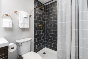 een badkamer met een wit toilet en een douche bij Hot Tub - Fire Pit - River - State Park - King Bed in Wingina