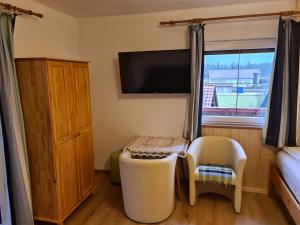 a room with a small table and a tv on the wall at Haus Alpenrose Obertraun in Obertraun