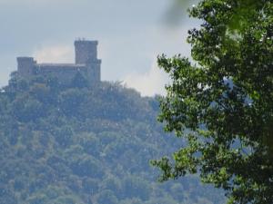 un castillo en la cima de una colina con árboles en La Vecchia Stalla B&B en Narni