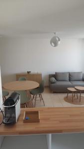 a living room with a couch and a table at Cocon douillet près de l'étang in Mèze