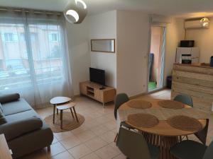 a living room with a table and a couch at Cocon douillet près de l'étang in Mèze