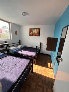 a room with two beds and a window at Hospedaje Casa Azul in Mexico City