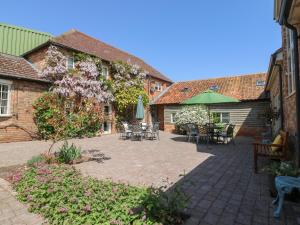 un cortile con tavoli e sedie e un ombrellone verde di BB House a Bedford