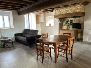 un salon avec une table en bois et un canapé dans l'établissement Maison de campagne rénovée, à Montaron