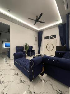 a living room with couches and a ceiling fan at Farisya Homestay in Kota Bharu