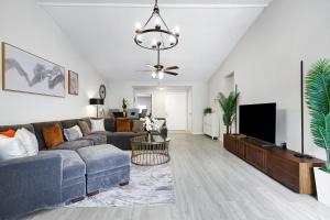 a living room with a couch and a tv at Modern Paradise Hot Tub Game Room Swing Set Bbq in San Antonio