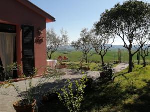 une maison avec vue sur un champ dans l'établissement Podere Quercia al Santo, à Lajatico