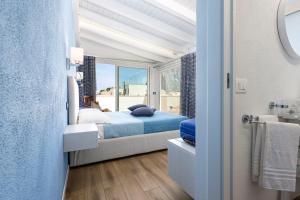 a bedroom with a bed and a window at Araba Fenice Hotel in San Vito lo Capo