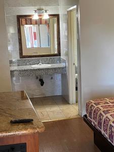a bathroom with a sink and a mirror at El Rio Motel in Glendale