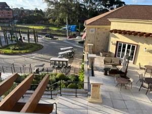a patio with tables and chairs and a building at GRAMADO BUONA VITTA RESORT Spa in Gramado