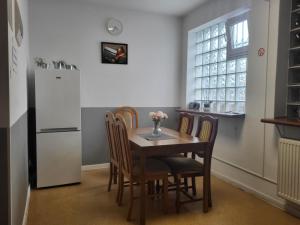 a kitchen with a table and chairs and a refrigerator at Rent Warszawa Ursynów in Warsaw