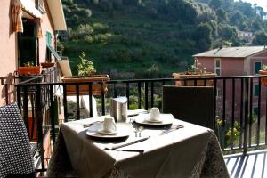 a table on a balcony with a view of a mountain at Marvit Affittacamere in Monterosso al Mare
