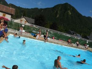 a group of people swimming in a swimming pool at Les 3 Ours in Couflens