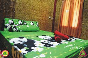 a bedroom with a bed with pandas on it at Sasak Lombok Bungalow in Kuta Lombok