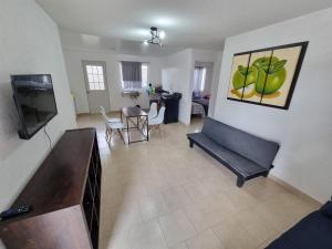 ein Wohnzimmer mit Sofa und Fernseher in der Unterkunft Hacienda de Cortés in Tlacote el Bajo