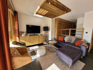 a living room with a couch and a tv at Exceptionnel duplex avec vue panoramique, terrasse et garage aux Gets - FR-1-598-36 in Les Gets
