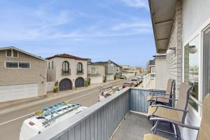 a balcony with chairs and a view of a street at Upper Level Beach Retreat in Newport Beach