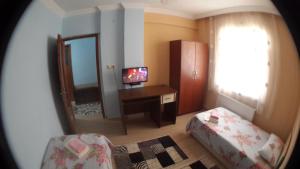 um quarto com um espelho e uma secretária com uma televisão em Ernur Pension em Canakkale