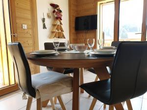 a dining room table with chairs and a christmas tree at Appartement Cosy 3 pièces avec Balcon, Garage et Wi-Fi - FR-1-598-40 in Les Gets