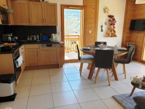 a kitchen with a table and a table and chairs at Appartement Cosy 3 pièces avec Balcon, Garage et Wi-Fi - FR-1-598-40 in Les Gets