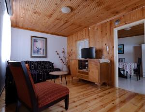 a living room with a tv and chairs and a table at Angelinas House in Glóssa