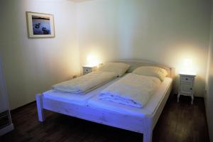 a bed in a room with two lights on two tables at Ferienwohnung Zauberland Stadum in Stadum +12 photos