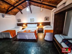 a bedroom with two beds and a table in it at Hotel Villar in Penedo +43 photos