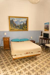 a bedroom with a bed and a painting on the wall at Hostel Albergue La Casa Encantada in El Paso