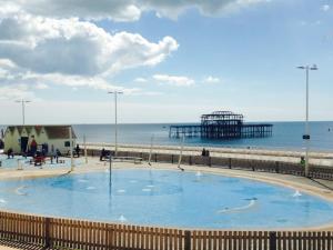 a large swimming pool next to a beach with a pier at Two Top Central Unique Artisan Beach Studios - also separate spa cabin in Brighton & Hove