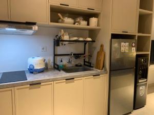 a kitchen with a stainless steel refrigerator and a sink at Cozy Studio Roseville BSD City by alonelyroom in Dadap