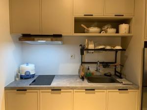 a kitchen with a sink and a counter top at Cozy Studio Roseville BSD City by alonelyroom in Dadap