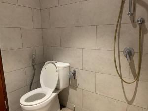 a bathroom with a shower with a toilet in it at Cozy Studio Roseville BSD City by alonelyroom in Dadap