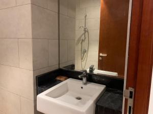 a white sink in a bathroom with a shower at Cozy Studio Roseville BSD City by alonelyroom in Dadap +32 photos