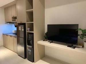 a living room with a flat screen tv on a wall at Cozy Studio Roseville BSD City by alonelyroom in Dadap