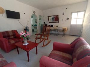 a living room with two couches and a table with flowers at Hospedaje Casa de la Abuela in Yuluc