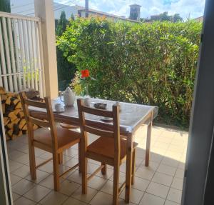 a table and two chairs on a porch with a table and a table at La parenthèse des collines in Saint-Donat-sur-lʼHerbasse