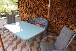 a table and chairs on a patio with a wall of wood at Gartenblick in Oranienbaum-Wörlitz
