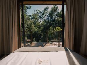 a bed in a room with a window at Tapada dos Vales in Arnoia